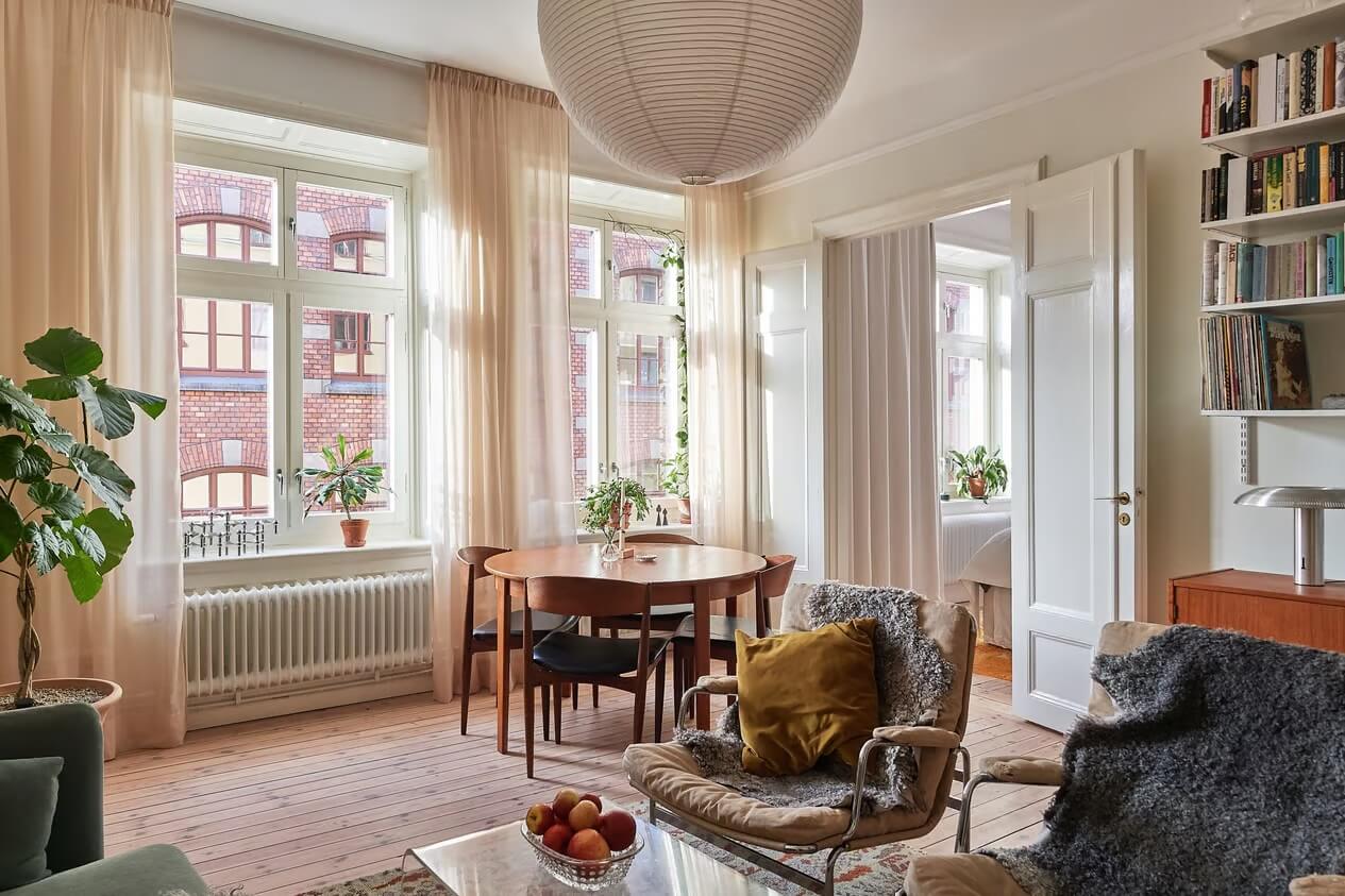 A Light Swedish Apartment with a Yellow Kitchen 6 living room large windows round wooden table