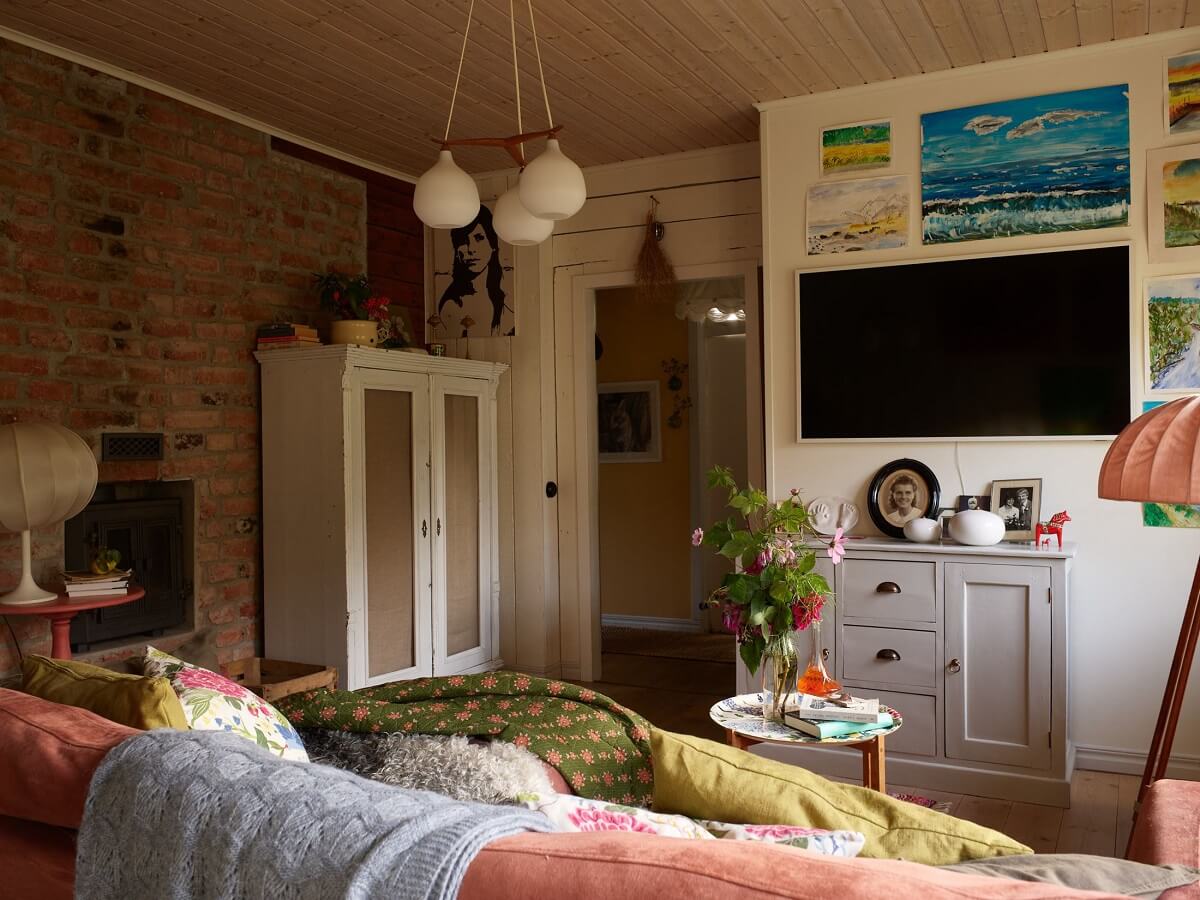 A Charming Swedish Cottage Filled with Art and Color 3 living room pink sofa brick wall