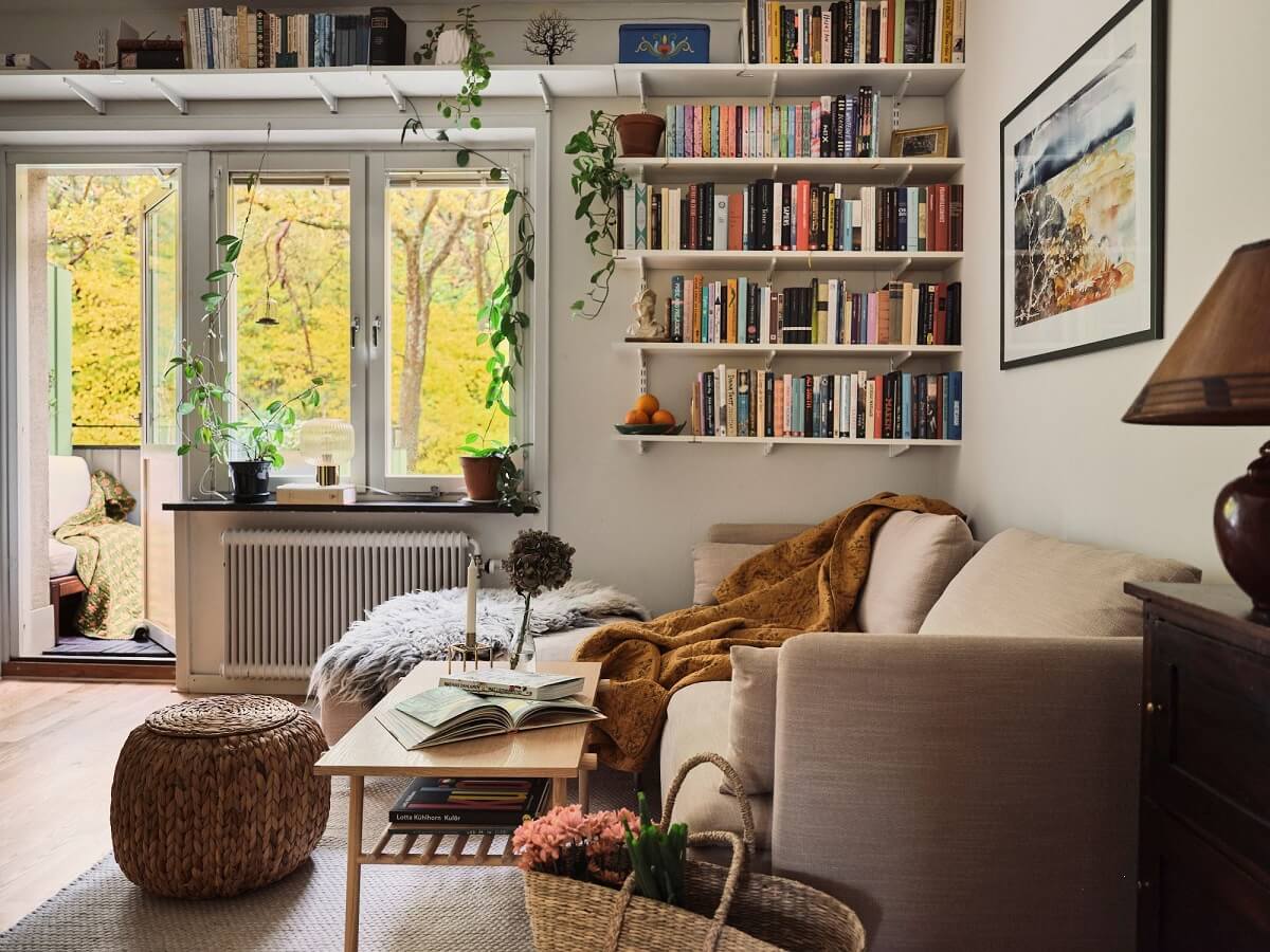 A Small Swedish Apartment with a Social and Semi-Open Floorplan 1 living room with bookshelves above window
