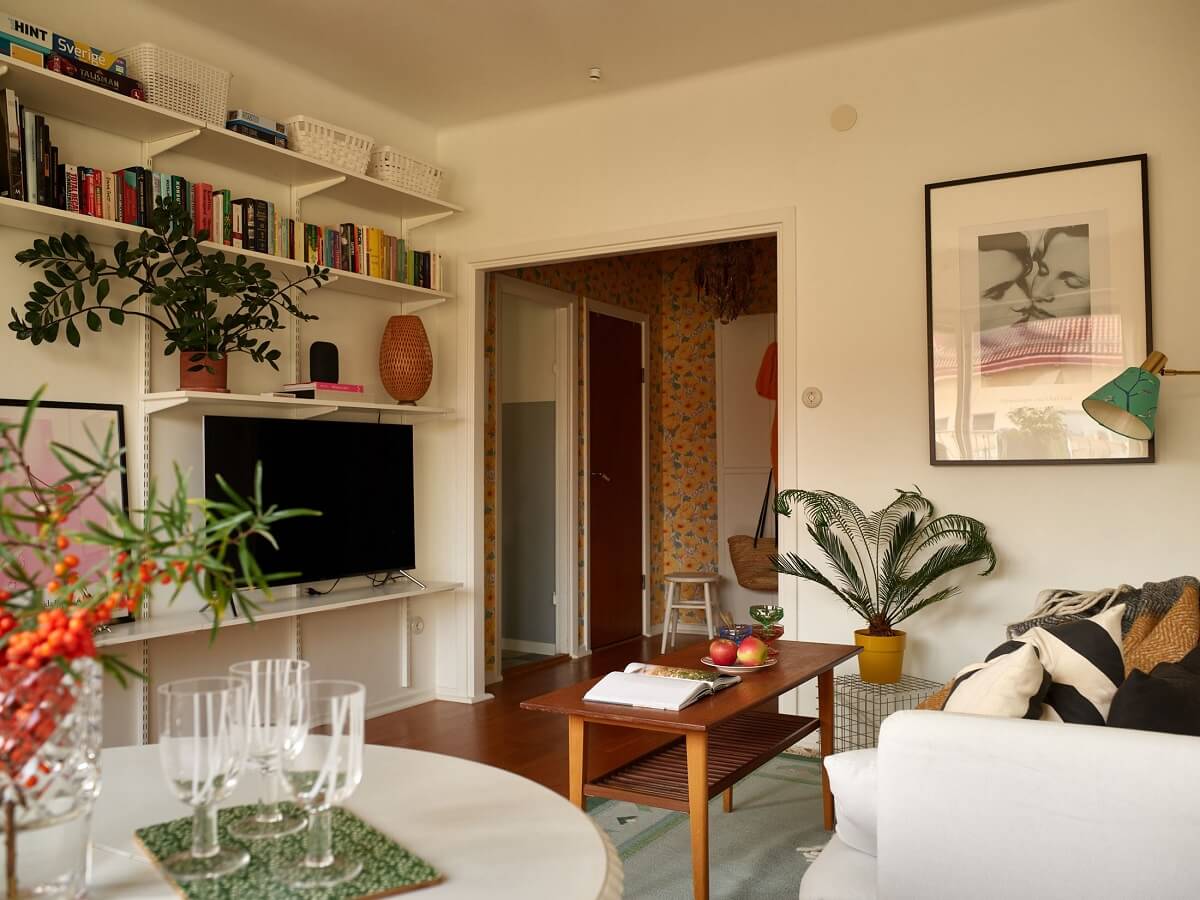 A Small 1930s Swedish Apartment with a Yellow Floral Hall 3 living room with green rug and shelves