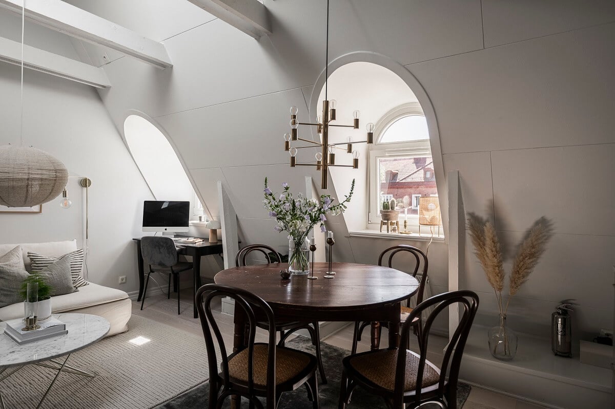 A Swedish Attic Apartment with a Lovely Balcony Overlooking the City 9 living room wooden beams dormer windows round wooden table