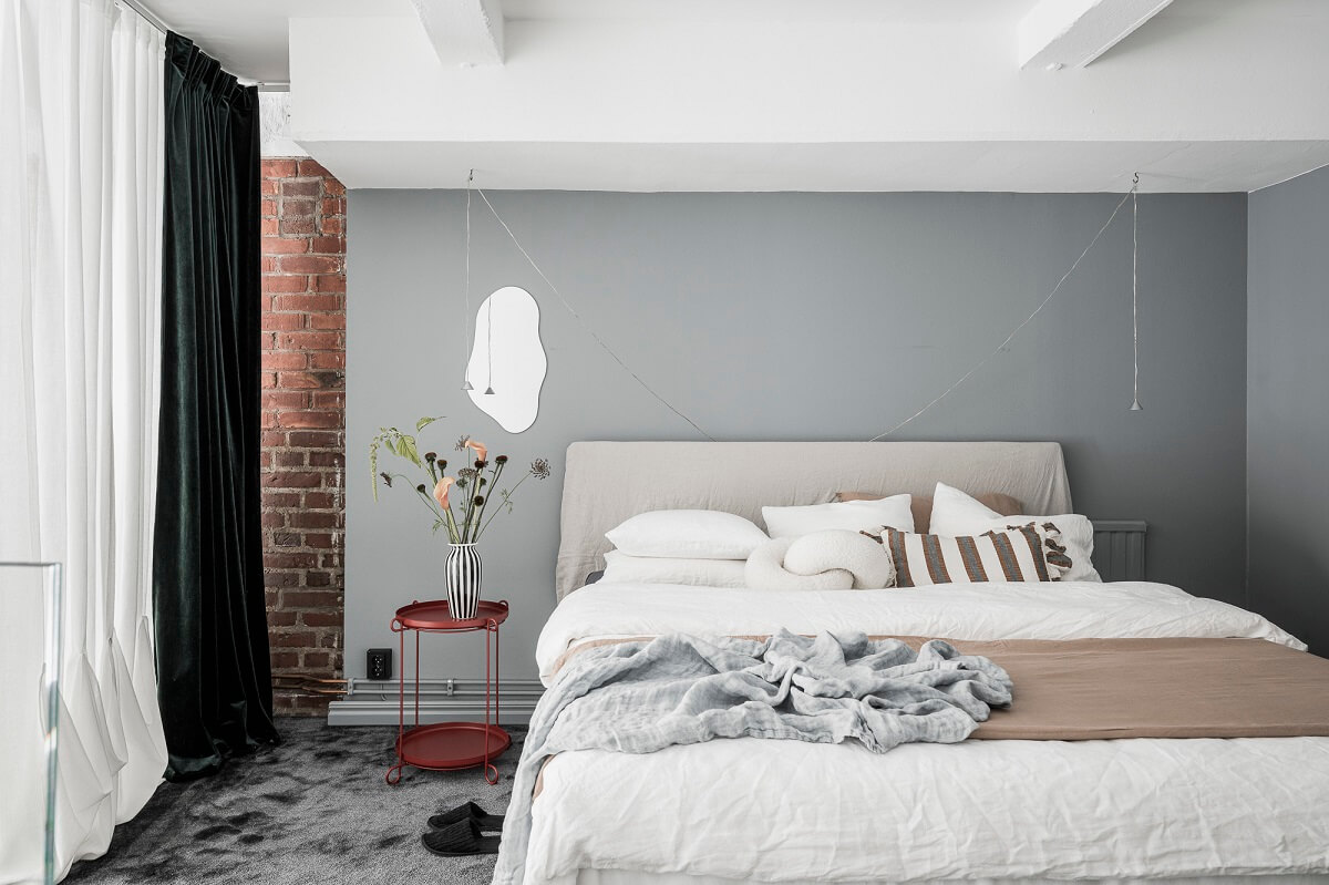 A Scandinavian Loft in an Old Industrial Building 17 loft bedroom exposed brick red bedside table