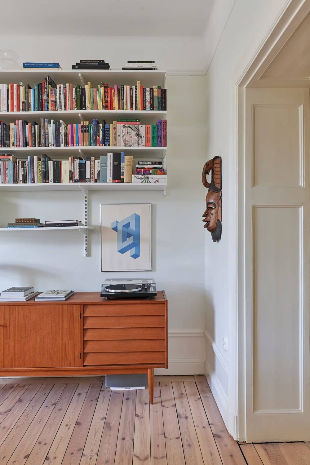 A Light Swedish Apartment with a Yellow Kitchen 5 midcentury cabinet and bookshelves