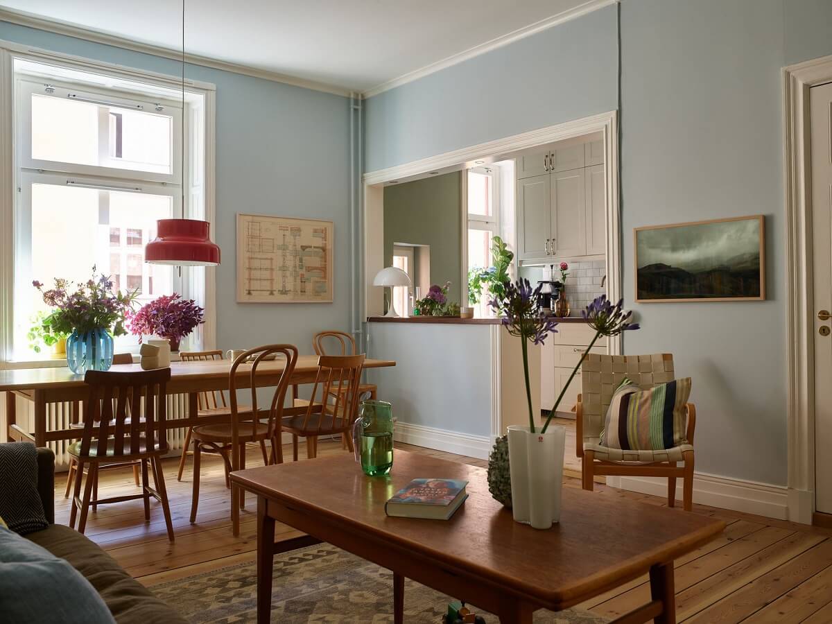 A Light Turn-of-the-Century Apartment with a Cheerful Color Palette 5 open living room light blue walls midcentury table