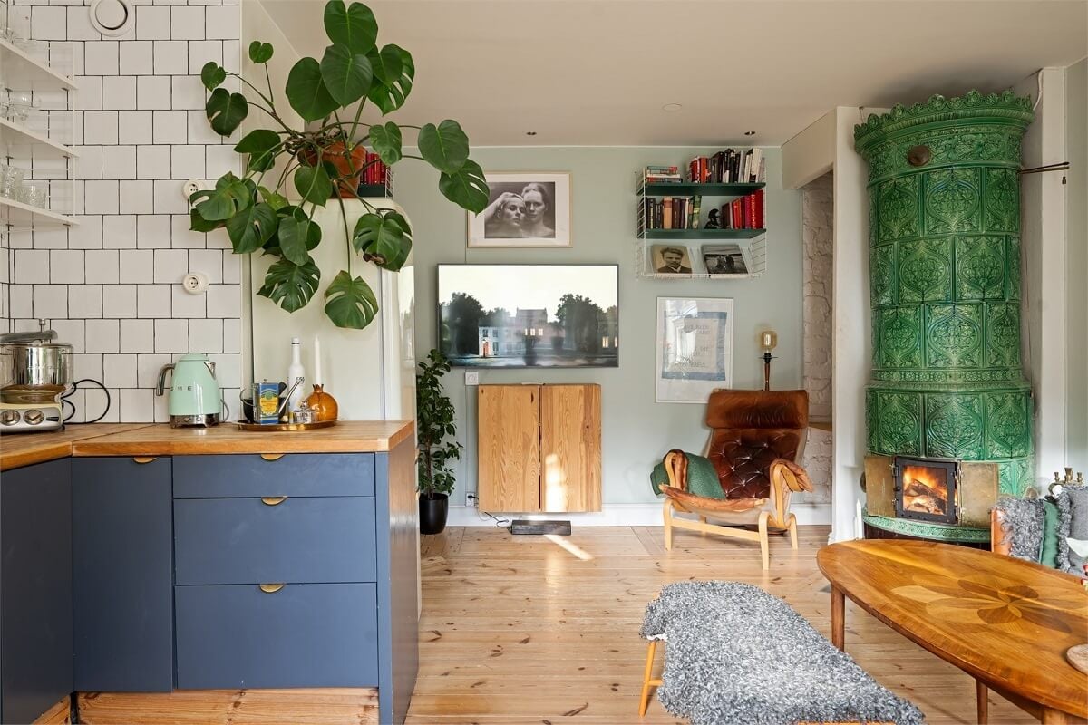 Green Tones in a Turn-of-the-Century Stockholm Apartment 7 open plan kitchen living room green fireplace