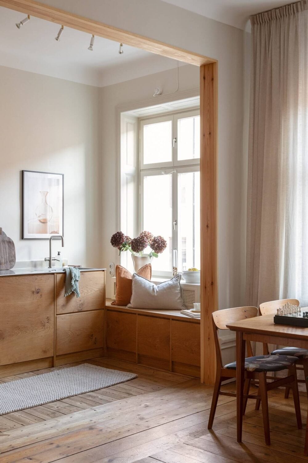A Turn-of-the-Century Apartment with Warm Open-Plan Spaces 10 open plan living room kitchen window seat