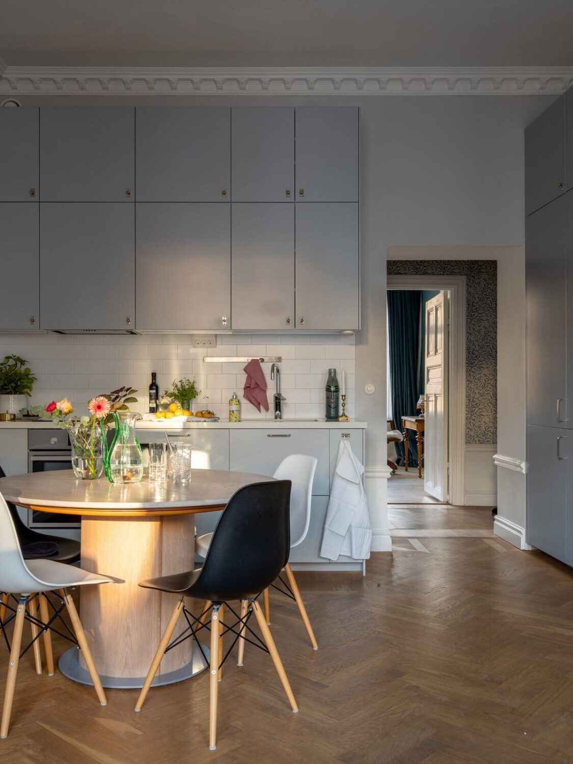 An 1890s Stockholm Apartment with a Blue Bedroom 4 open plan living room kitchen with gray cabinets and round table