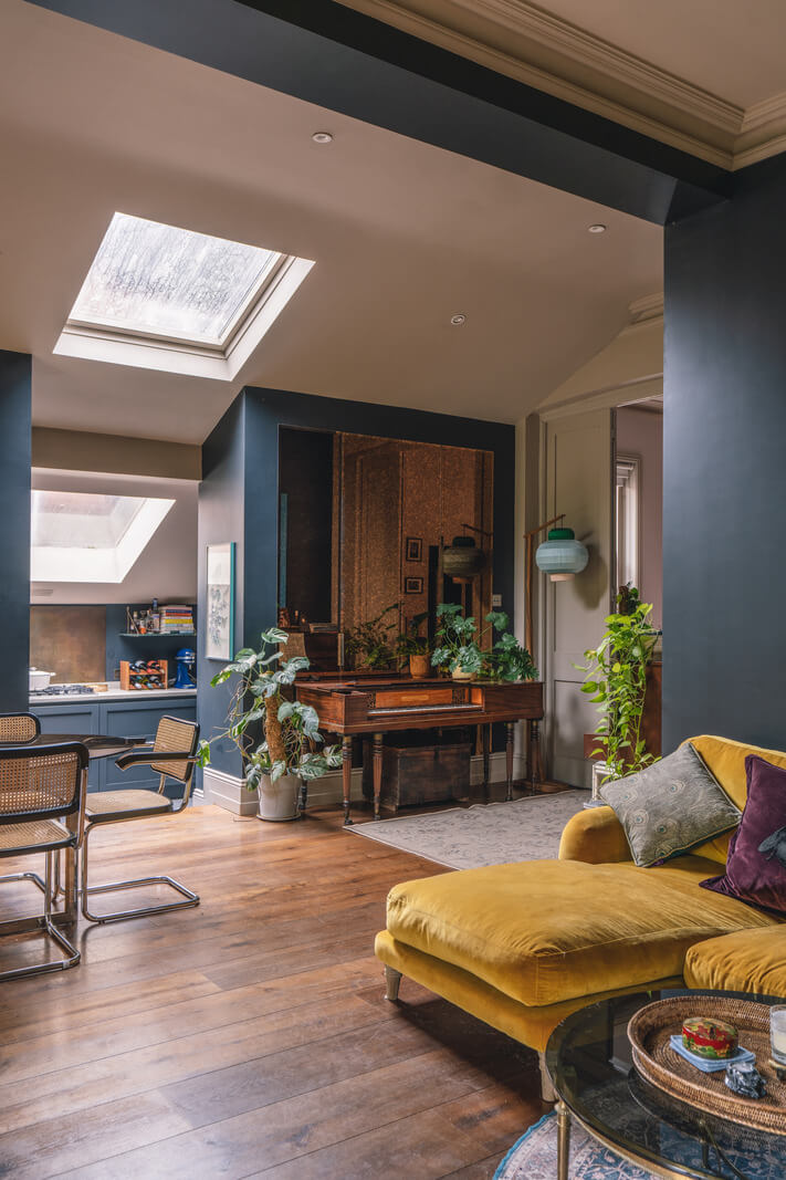 A Grand Ground Floor Apartment with Dark Blue Walls and a Garden 3 open plan living space with dark blue walls pitched ceiling and ochre couch nordroom