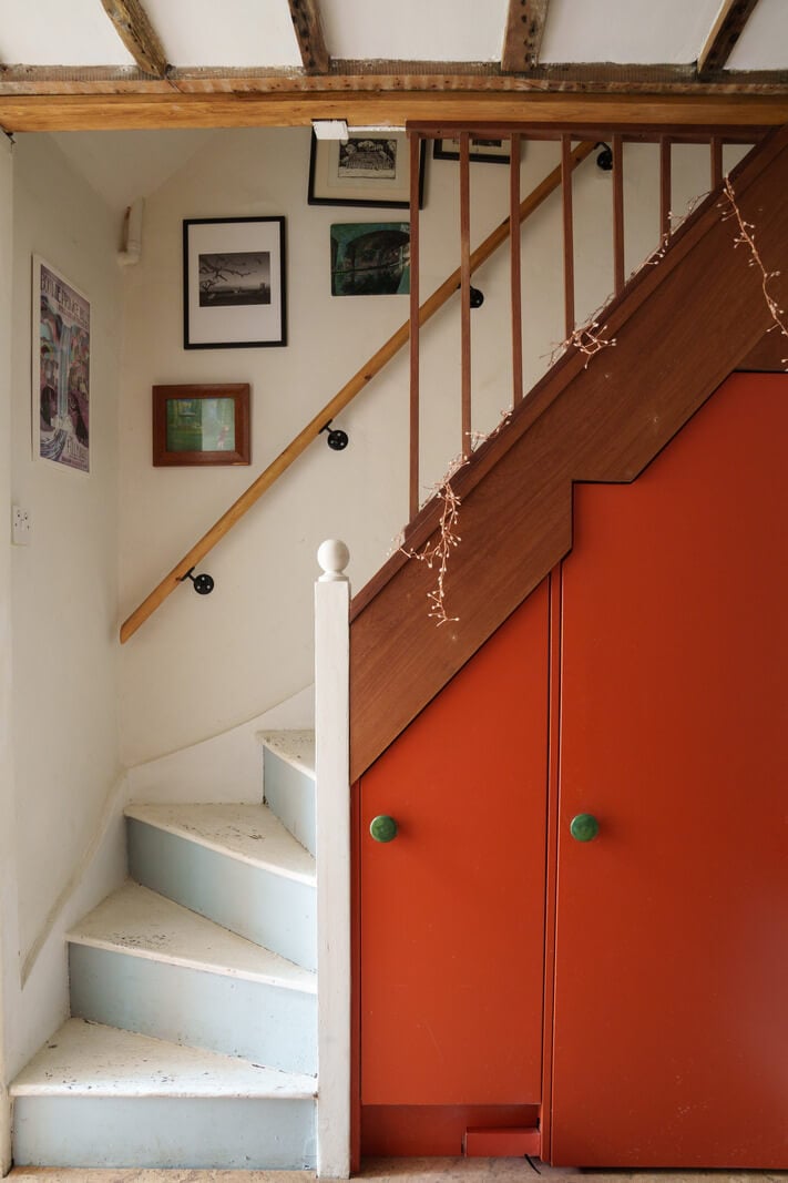 Colorful Furniture in a Historic English Cottage 8 orange cabinets under stairs