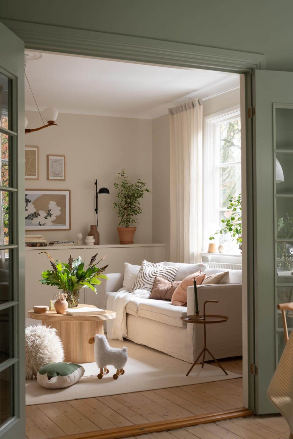 A Swedish Apartment Painted in Calm Beige, Green, and Pink Tones 5 peek into beige living room
