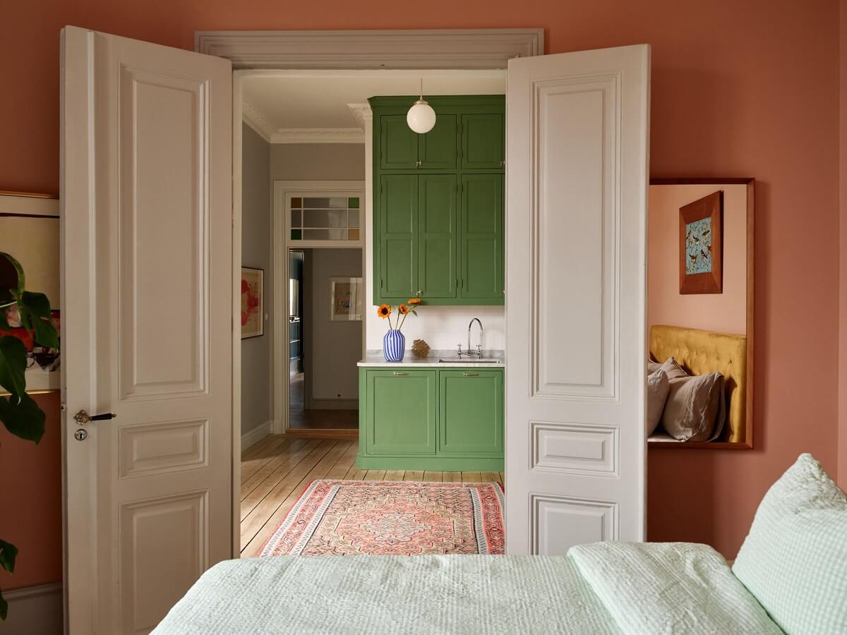A Colorful Turn-of-the-Century Family Apartment in Stockholm 23 pink bedroom double wooden doors to kitchen