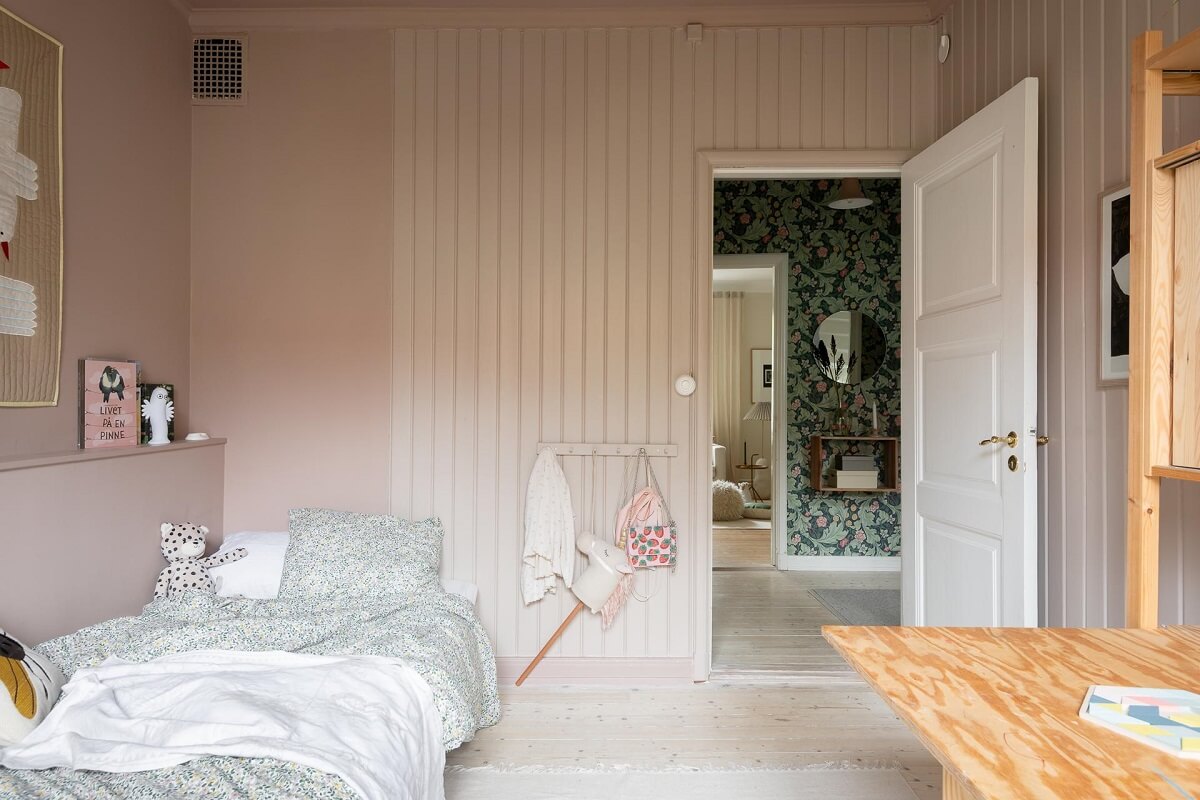 A Swedish Apartment Painted in Calm Beige, Green, and Pink Tones 24 pink kids bedroom wooden panels accent wall
