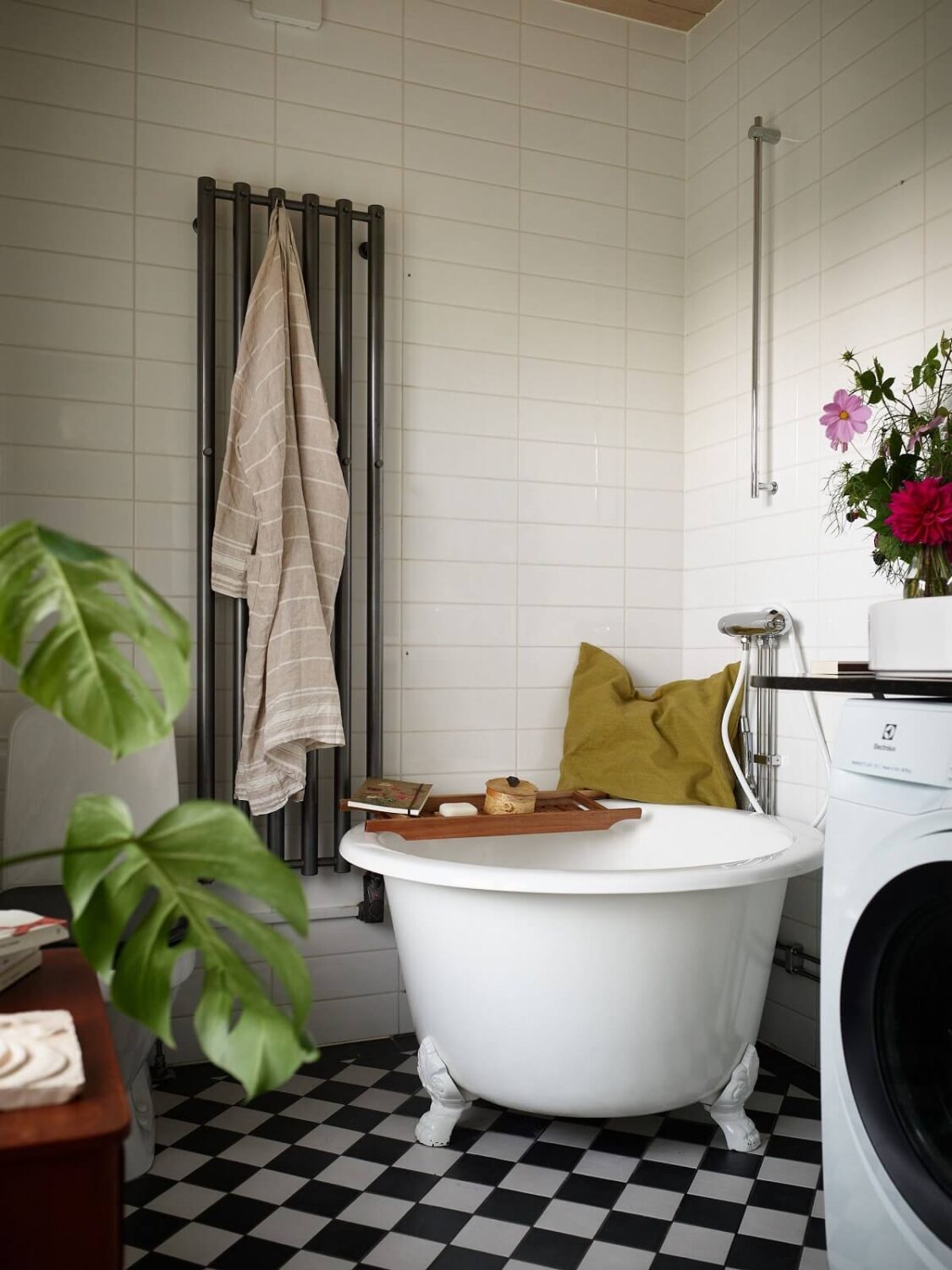 A Charming Swedish Cottage Filled with Art and Color 18 round tub in bathroom with checkerboard floor