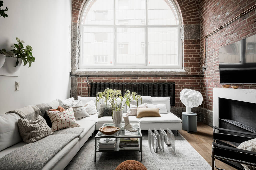 A Scandinavian Loft in an Old Industrial Building 3 scandi loft sitting room with brick wall and arched window