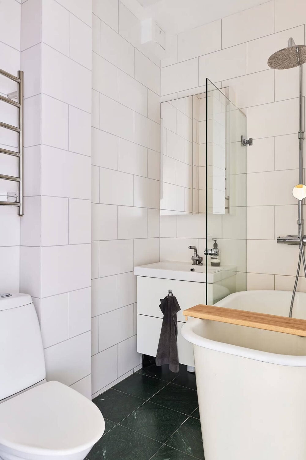 A Light Swedish Apartment with a Yellow Kitchen 20 simple bathroom black floor tiles white wall tiles and bath shower combo A Light Swedish Apartment with a Yellow Kitchen