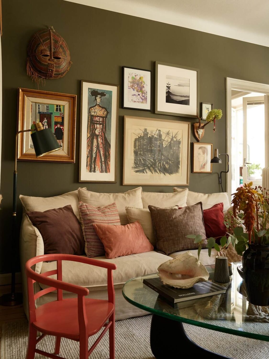 A Lovely Apartment Owned By The Same Family for Almost 100 Years 2 sitting room dark green wall with art