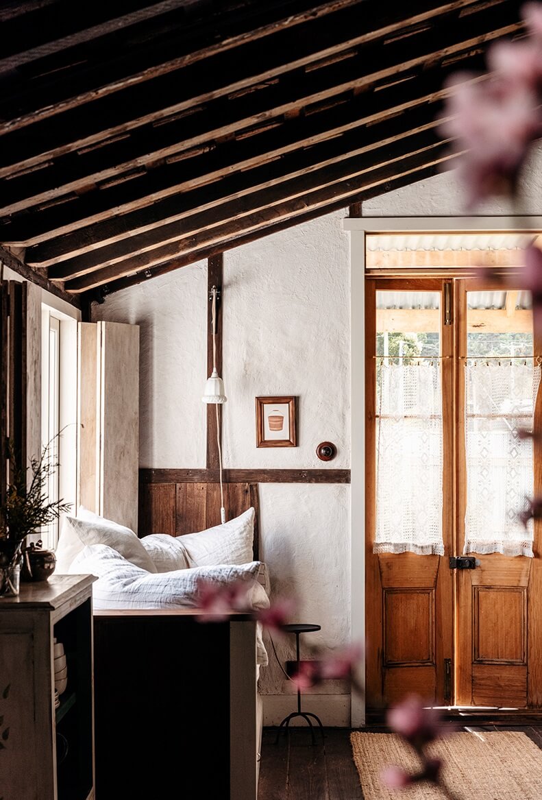 A Cozy Rustic Shipbuilder's Cottage in Northern Tasmania 7 slanted wooden ceiling window seat kitchen