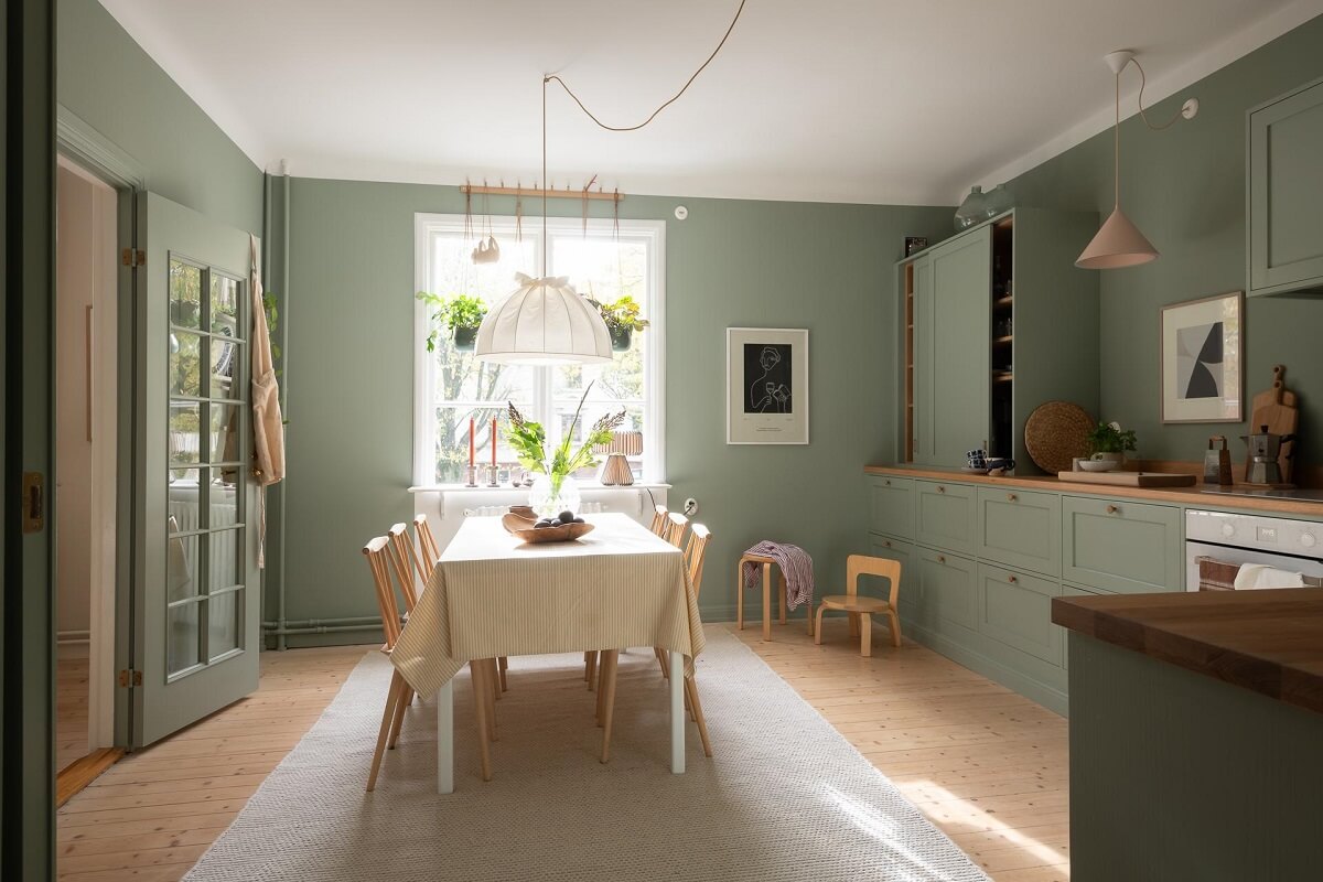 A Swedish Apartment Painted in Calm Beige, Green, and Pink Tones 11 spacious green kitchen plants hanging in front of window