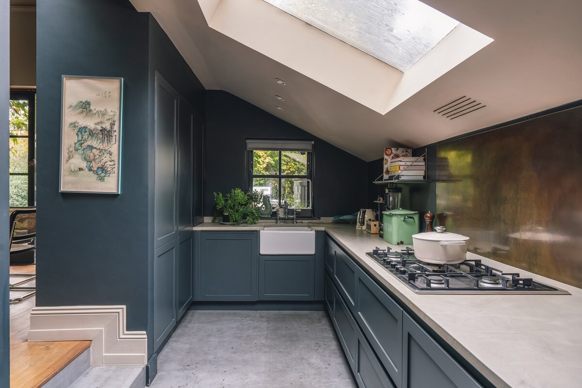 A Grand Ground Floor Apartment with Dark Blue Walls and a Garden 7 sunken kitchen with dark blue cabinets and walls and skylight