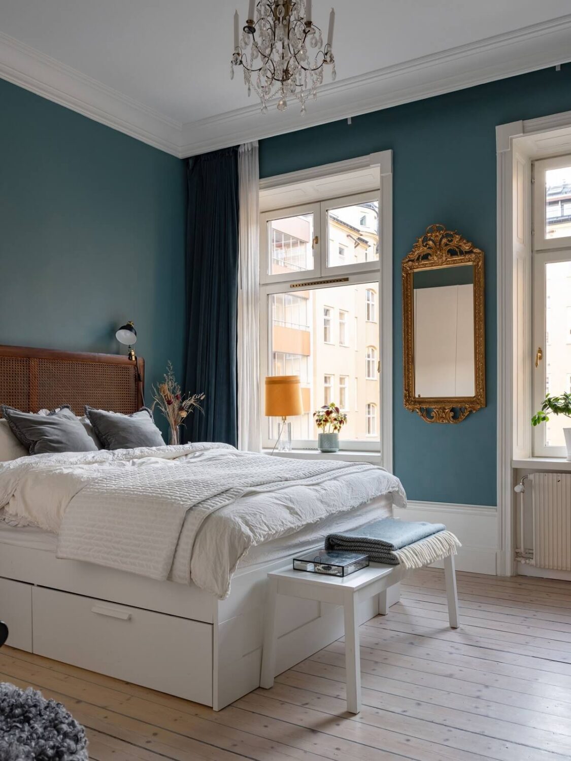 An 1890s Stockholm Apartment with a Blue Bedroom 8 teal blue walls and cane headboard gilded mirror nordroom