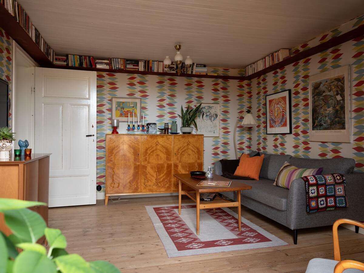 A 1930s Green-Painted Wooden Family Home in Sweden 16 television room with colorful wallpaper and bookshelves