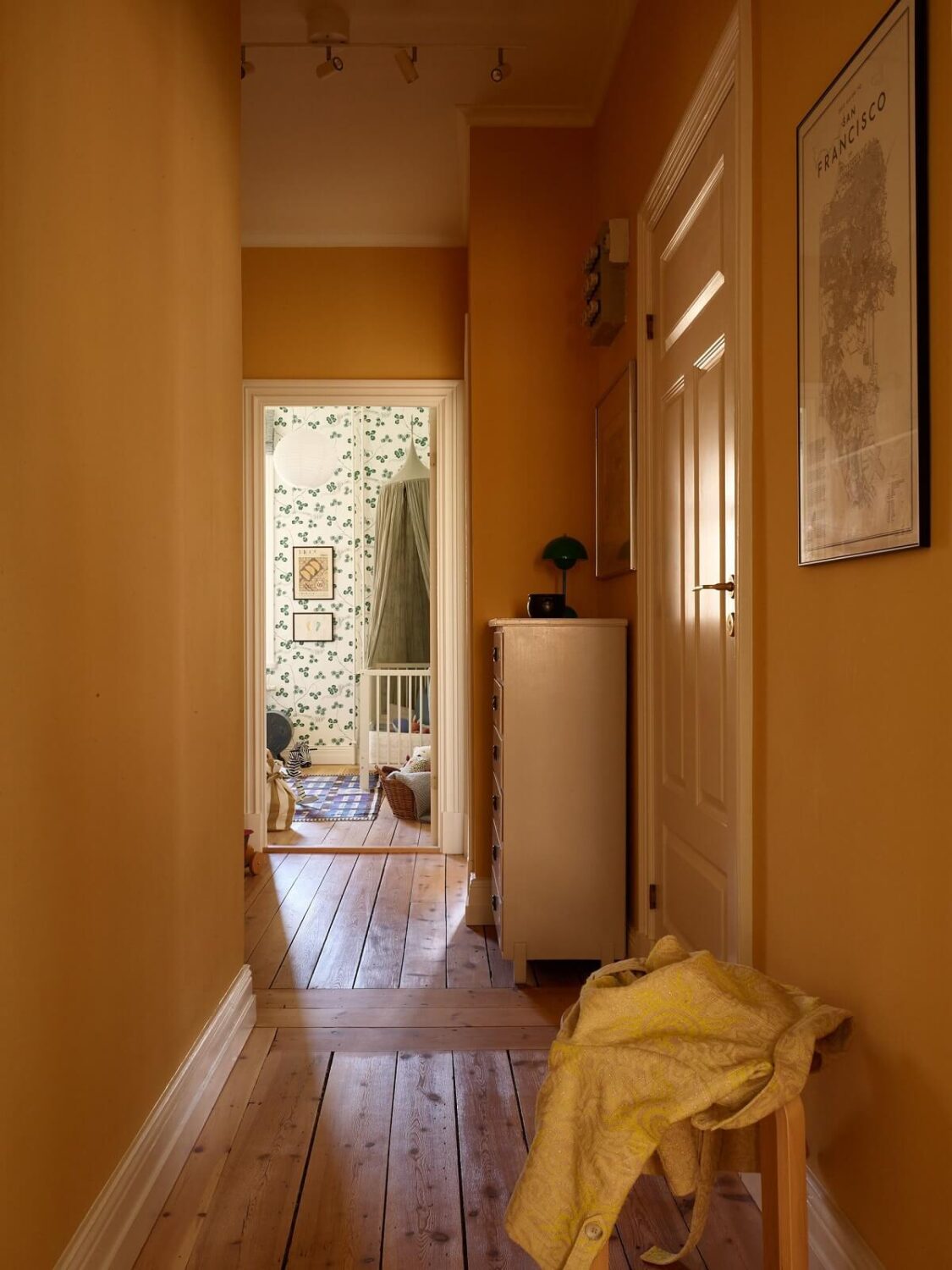 A Light Turn-of-the-Century Apartment with a Cheerful Color Palette 21 warm yellow hallway with wooden floor A Light Turn-of-the-Century Apartment with a Cheerful Color Palette