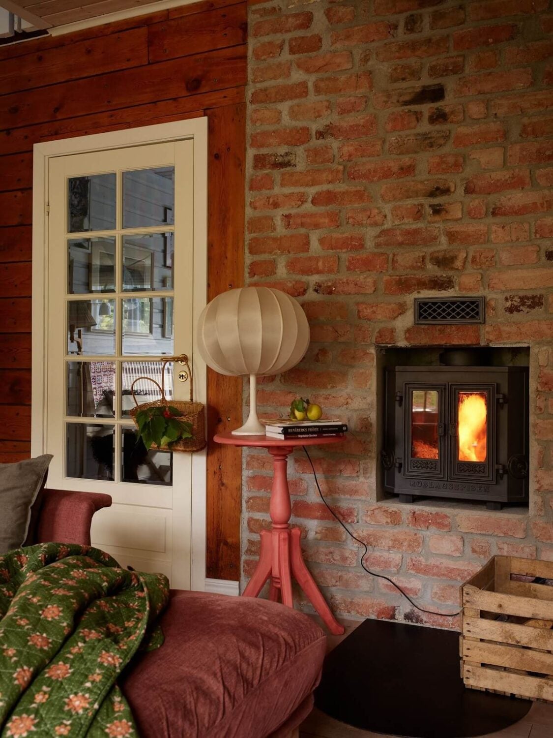 A Charming Swedish Cottage Filled with Art and Color 4 wood burner in brick wall swedish cottage