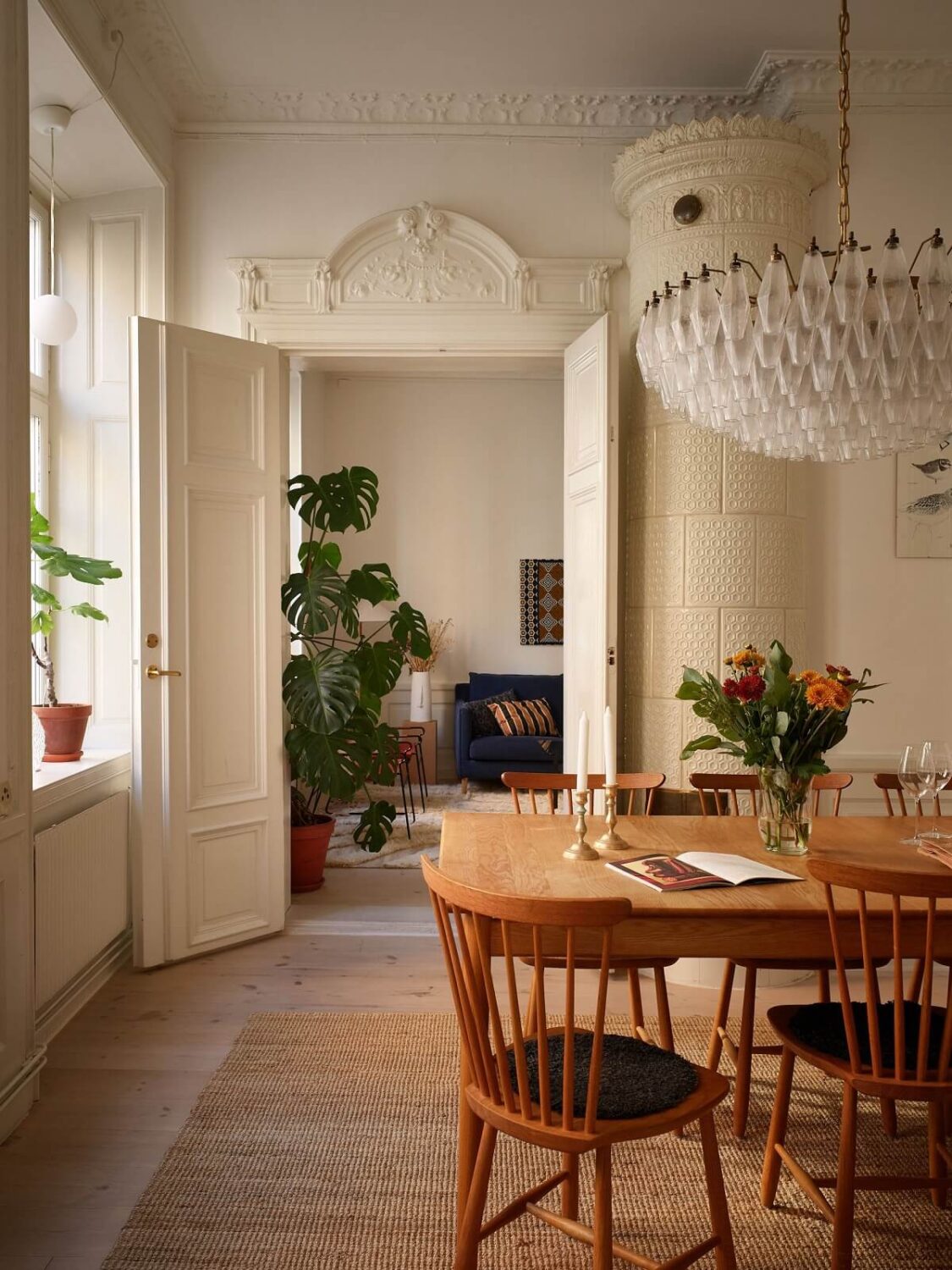 A Light Corner Apartment with 1890s Period Features 9 wooden dining table fireplace large chandelier