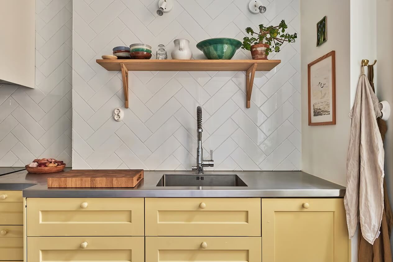 A Light Swedish Apartment with a Yellow Kitchen 17 yellow cupboards stainless steel worktop wooden shelf