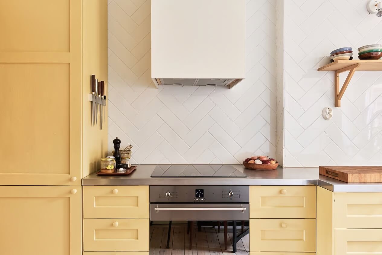 A Light Swedish Apartment with a Yellow Kitchen 16 yellow cupboards white tiles