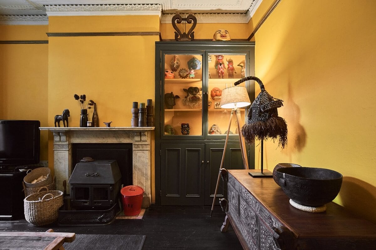A Grand Victorian House with Many Period Features and a Lush Garden 11 yellow sitting room with dark floor and fireplace
