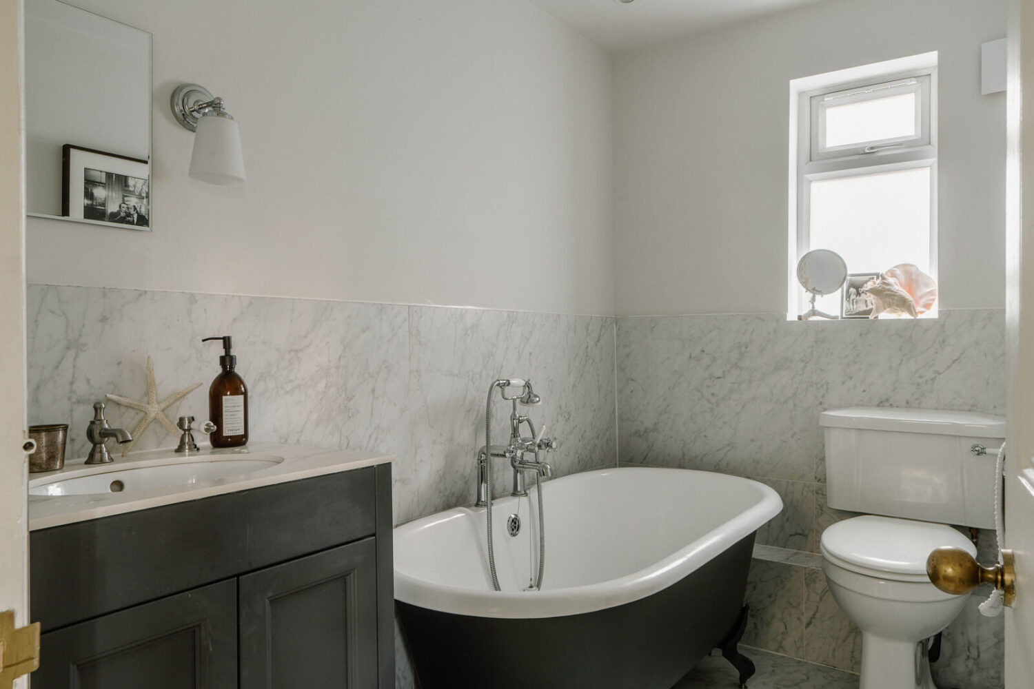 French and Midcentury Influences in a Charming London Studio Apartment 13 bathroom with bath and marble tiles