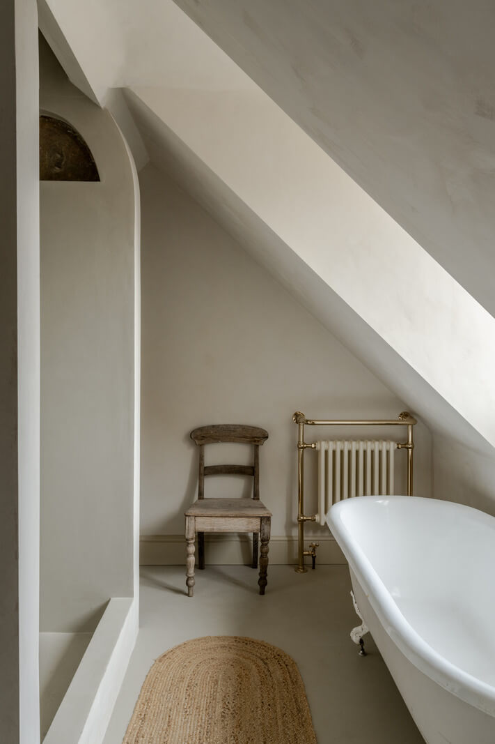 A Light Rustic Farmhouse-Style in an English Cottage 20 bathroom with slanted ceiling and freestanding bath nordroom