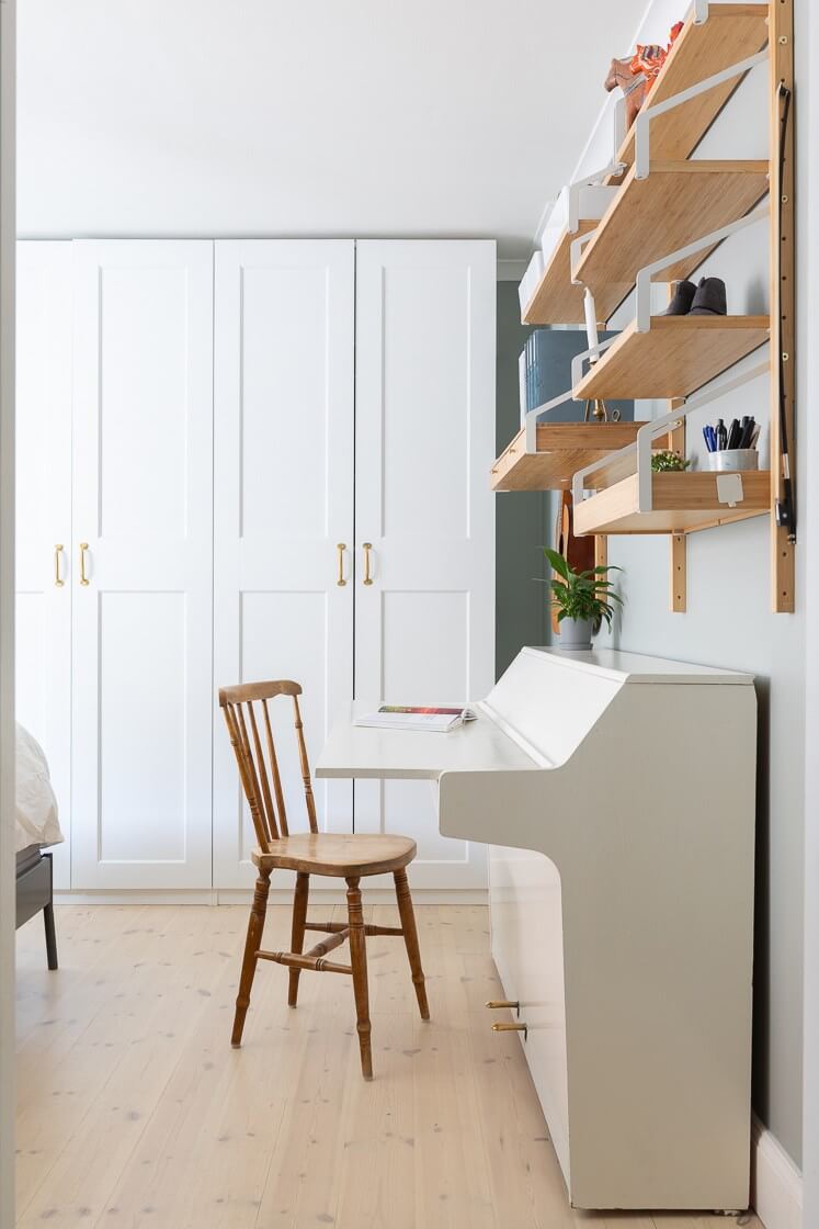 A Small and Bright Two-Bedroom Apartment in Stockholm 22 bedroom with piano and shelves