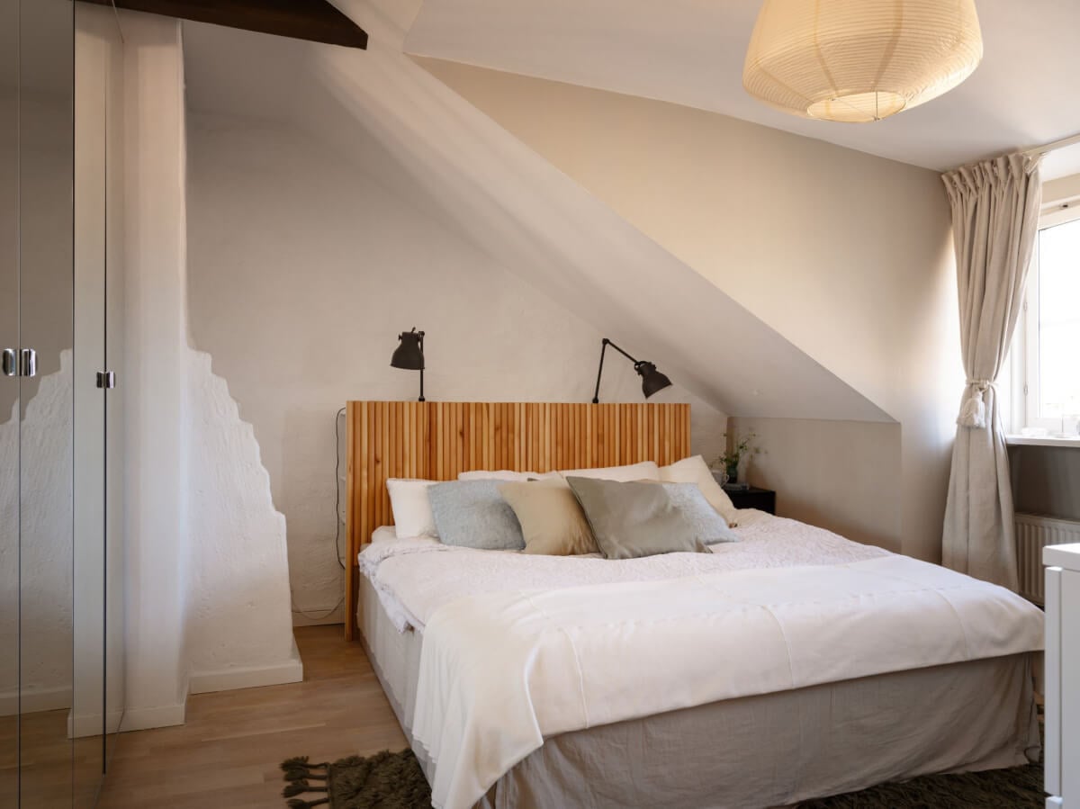 A Charming Light-Filled Attic Apartment with a Dark Oak Kitchen 17 bedroom with slanted ceiling