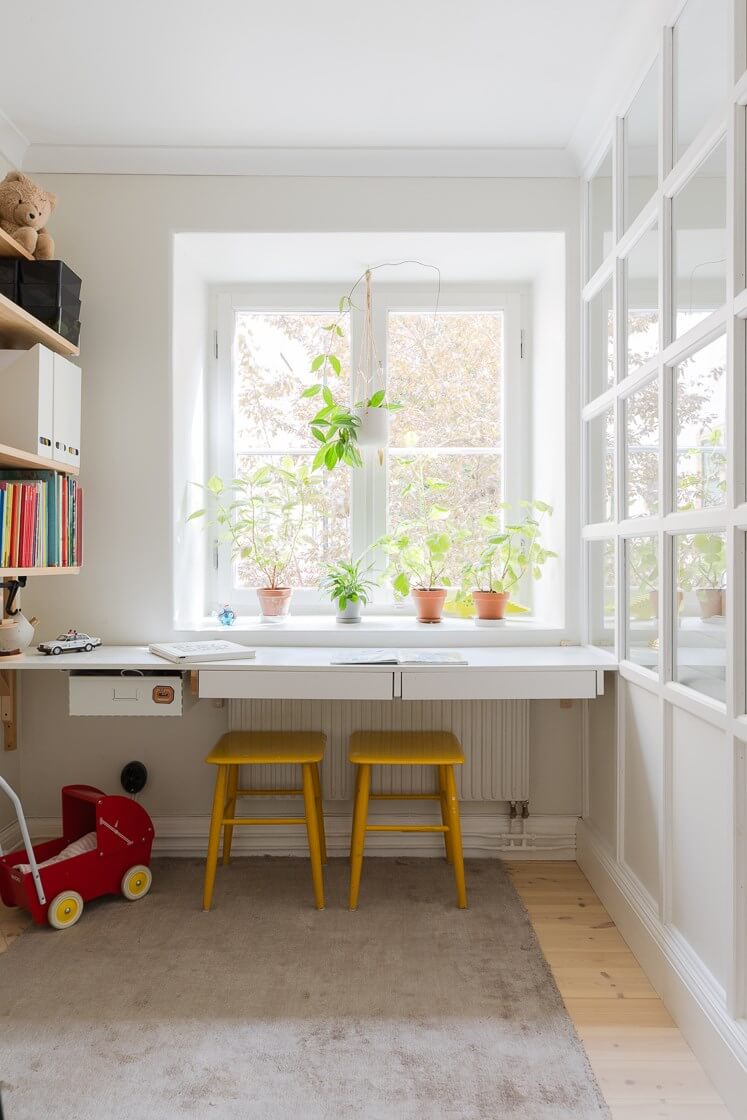 A Small and Bright Two-Bedroom Apartment in Stockholm 8 childrens bedroom with desk under window and yellow stools