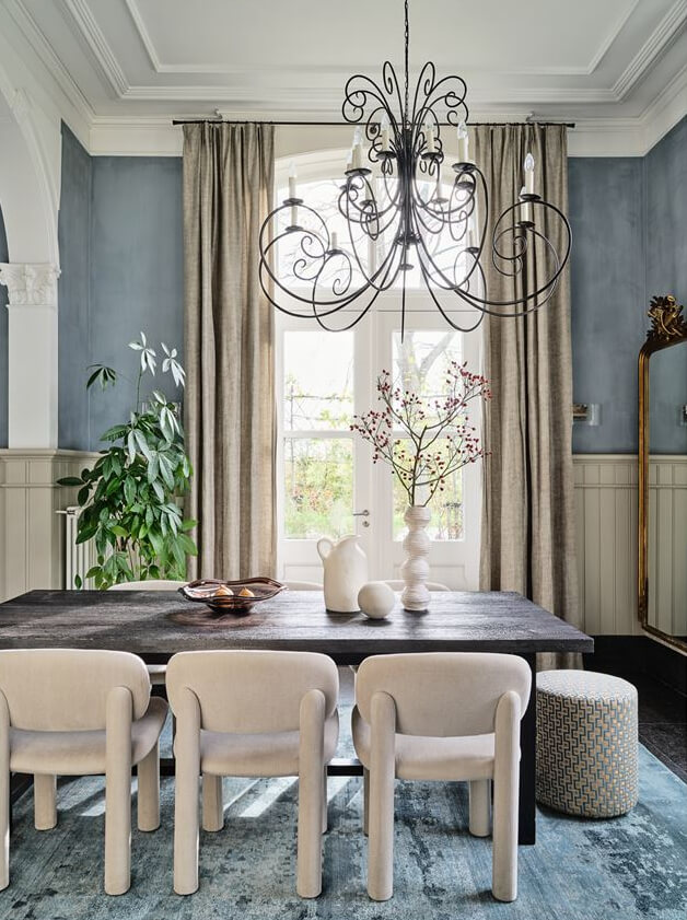 An Amazing Family Home in a Former Dutch Train Station 3 classic modern dining room with velvet chairs and large blue rug nordroom