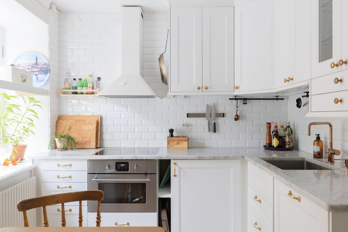 A Small and Bright Two-Bedroom Apartment in Stockholm 14 classic white kitchen brass fittings marble countertop