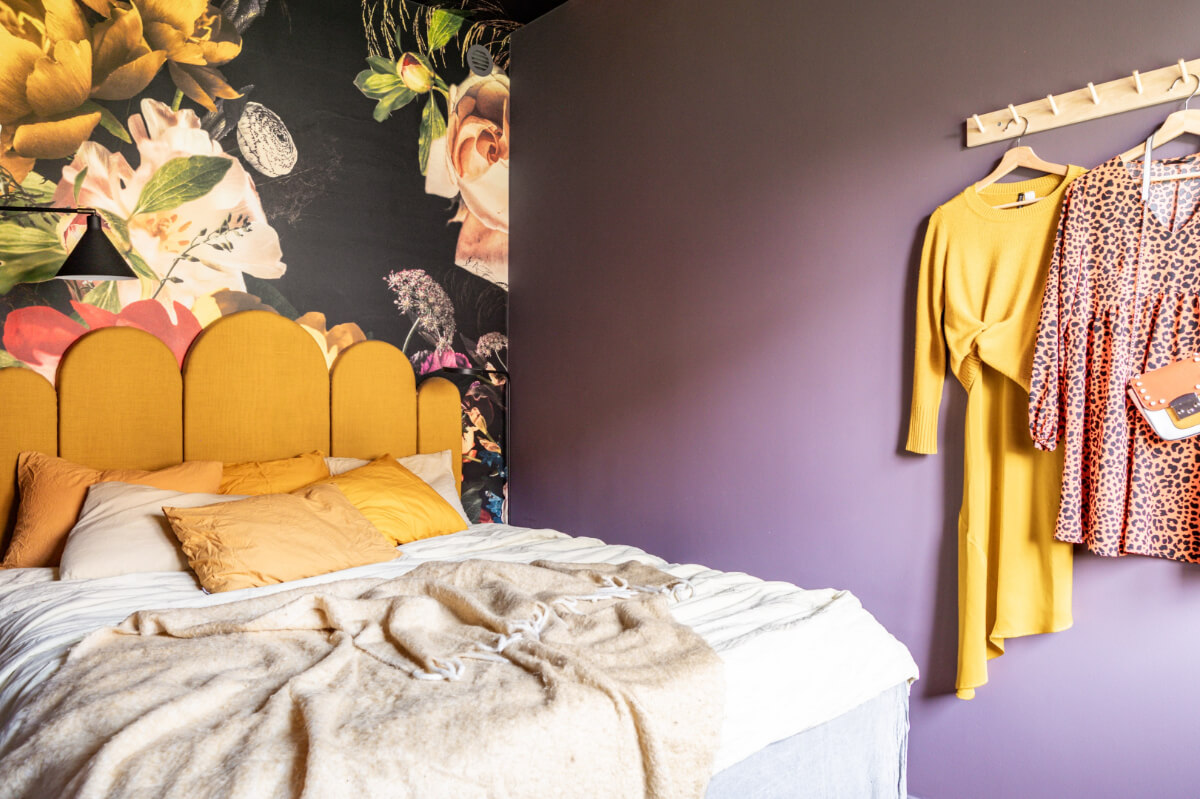 A Vibrant, Colorful Midcentury Apartment in Malmö 17 colorful bedroom with purple wall floral mural and yellow headboard