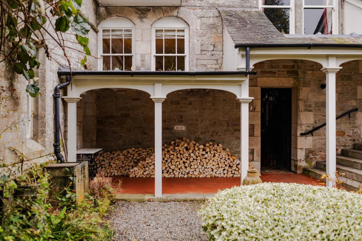 A Strong Color Palette in a Unique Country House in Cornwall 28 covered porch with chopped wood