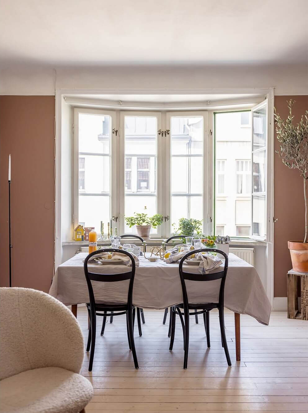 A Spacious Nordic Apartment with a Wonderful Color Palette 6 dining table in front of window in earthy pink living room
