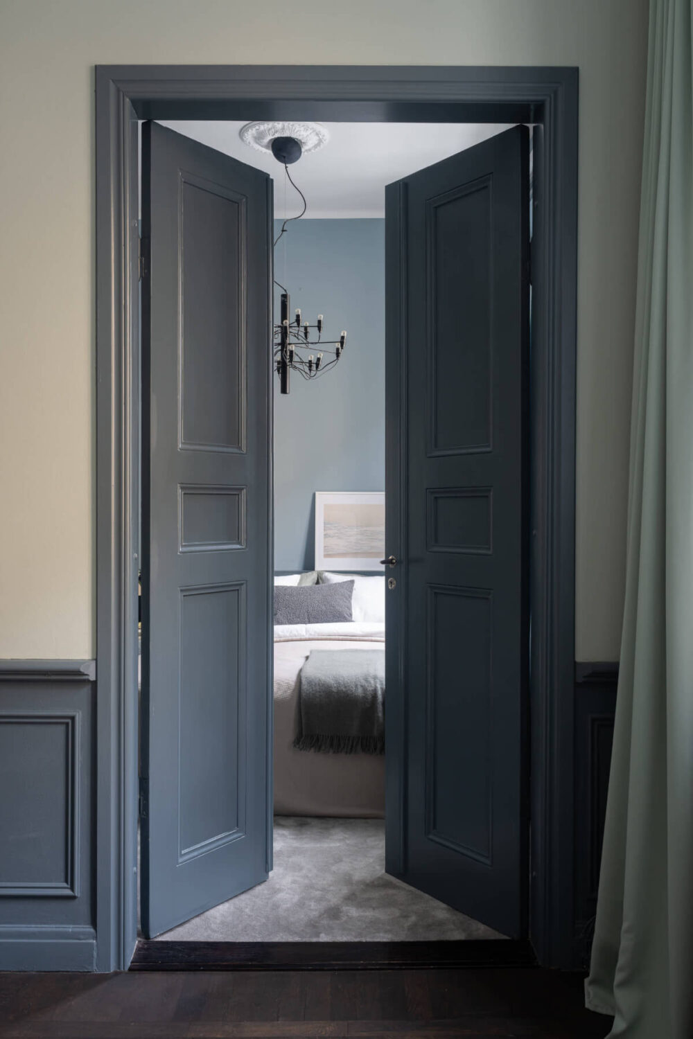 A Moody Color Palette in a Stylish One-Bedroom Apartment in Stockholm 13 double wooden doors to bedroom