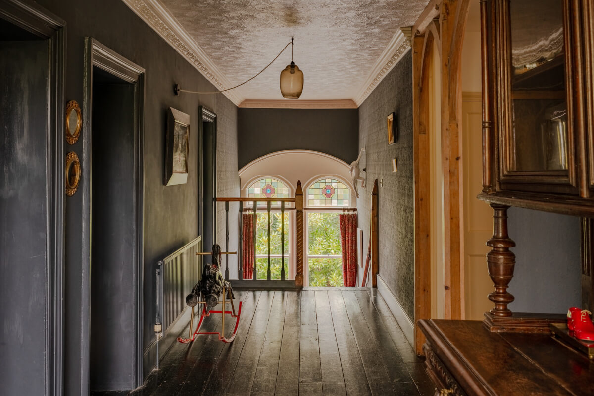 A Strong Color Palette in a Unique Country House in Cornwall 13 dramatic first floor landing with dark walls