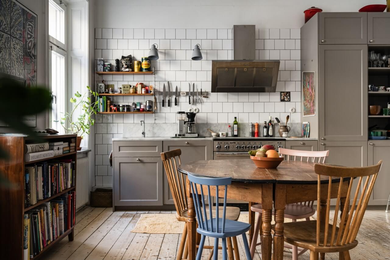 Muted Tones, Art, and Books in a Charming Stockholm Apartment 6 gray beige kitchen with white tiles and round wooden table