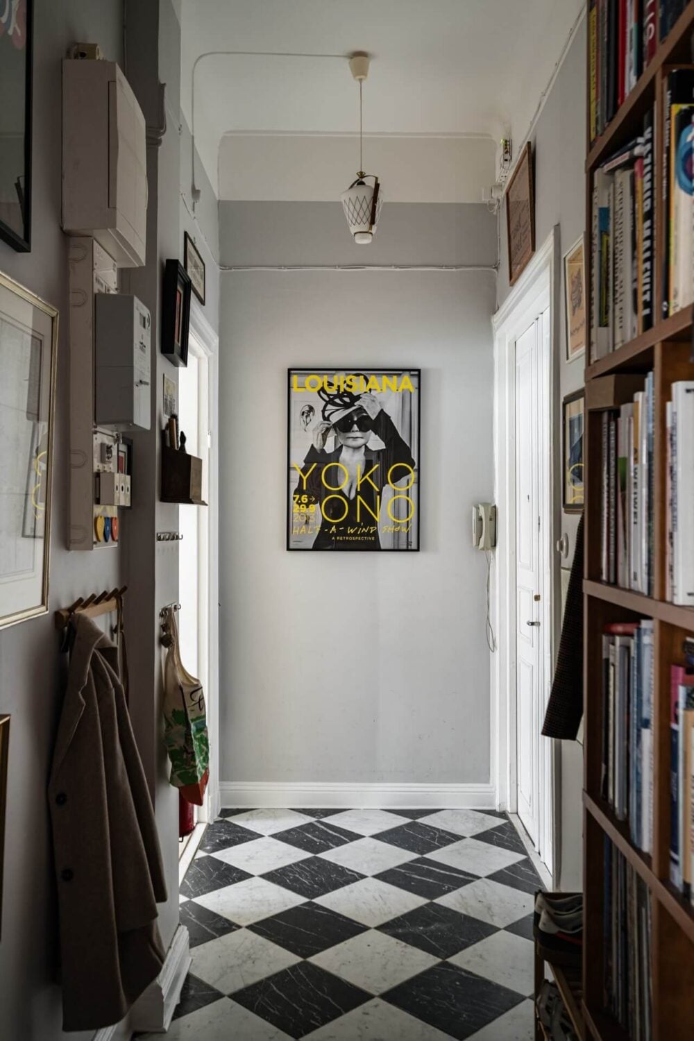 Muted Tones, Art, and Books in a Charming Stockholm Apartment 15 hall with checkerboard marble floor and bookcases