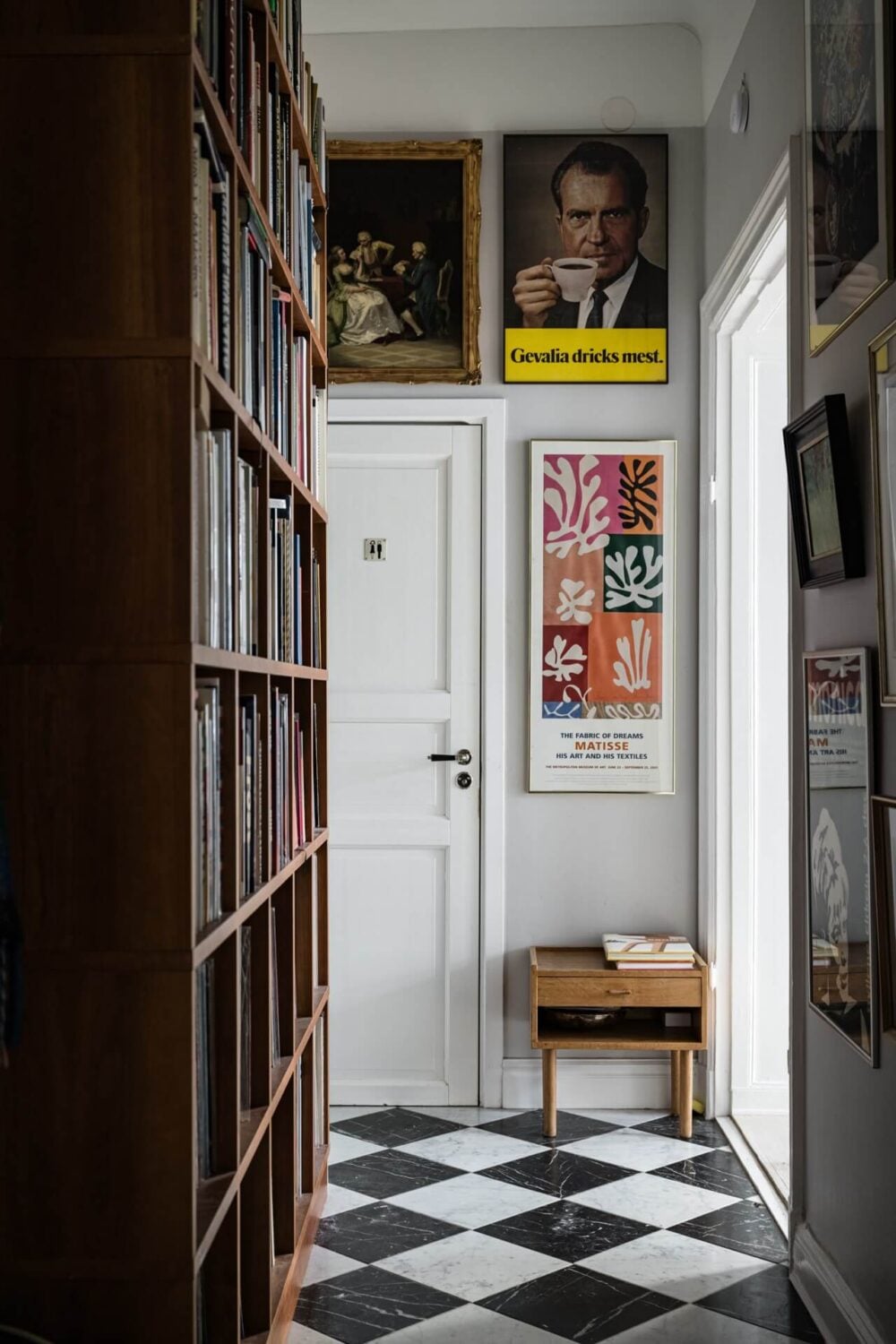 Muted Tones, Art, and Books in a Charming Stockholm Apartment 18 hallway with black and white floor tiles art and books