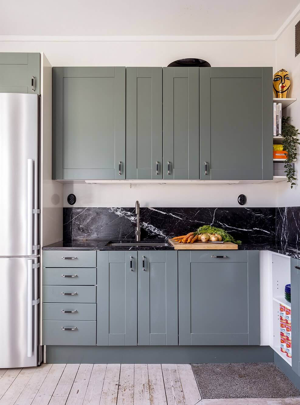 A Spacious Nordic Apartment with a Wonderful Color Palette 17 kitchen with blue-green cabinets and black marble worktop