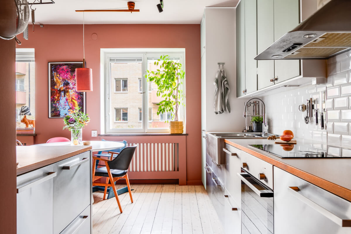 A Vibrant, Colorful Midcentury Apartment in Malmö 11 kitchen with stainless steel and green cabinets