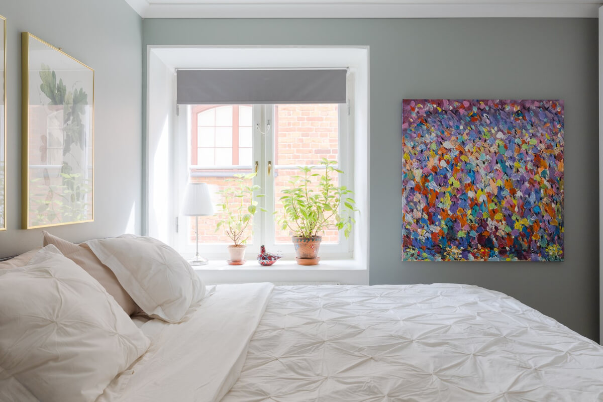 A Small and Bright Two-Bedroom Apartment in Stockholm 20 light gray bedroom with colorful art
