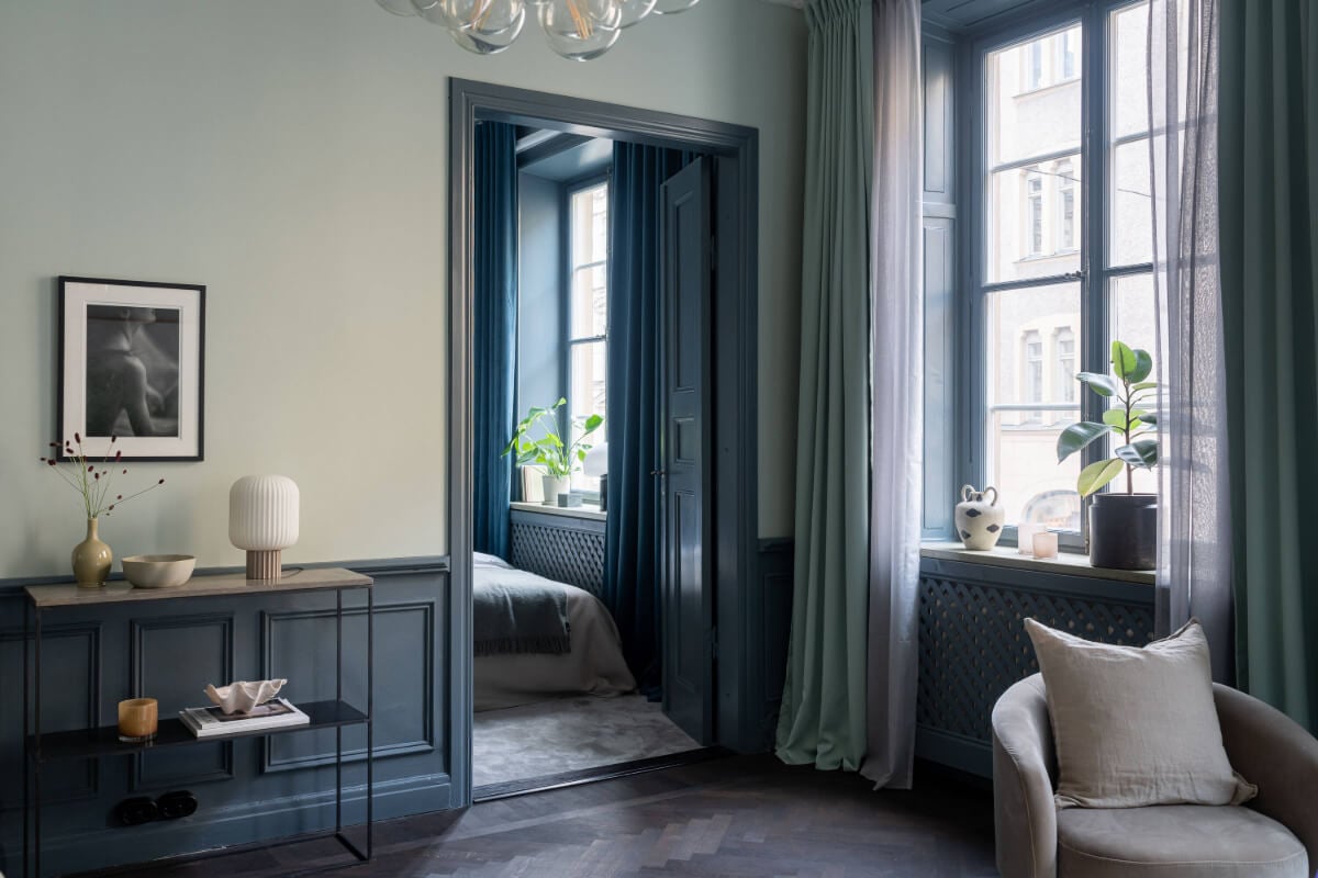 A Moody Color Palette in a Stylish One-Bedroom Apartment in Stockholm 8 living room with access to blue bedroom